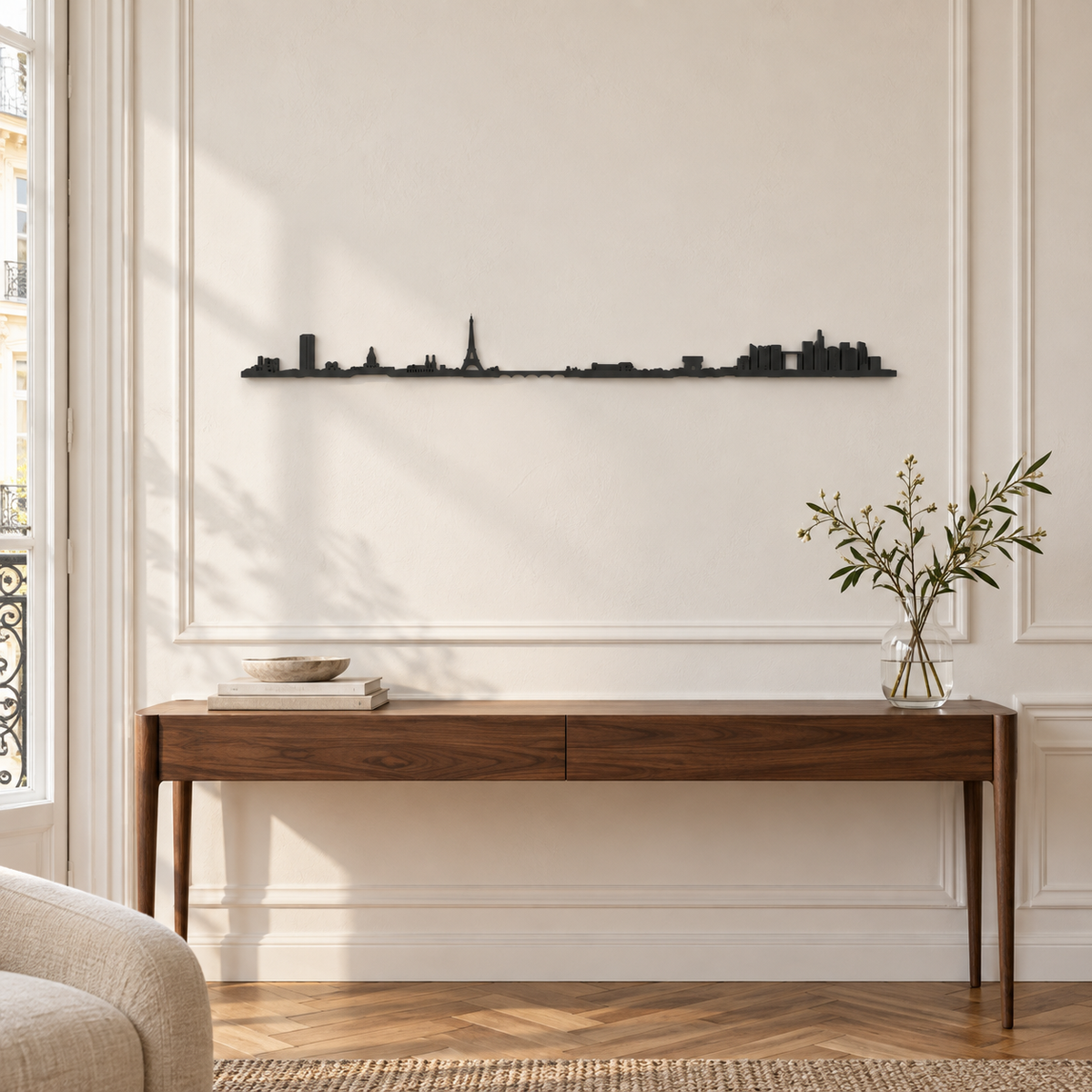 Skyline de París en madera negra sobre una consola, en una pared blanca con molduras y luz natural.