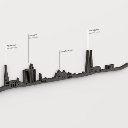 Skyline de Bielefeld en acabado negro con nombres de Altstädter Nicolaikirche, Telekom- Hochhaus, Altes Rathaus, Neustädter Marienkirche.
