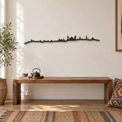 Skyline de Estambul en madera negra sobre un banco de madera con una tetera y una alfombra de colores.