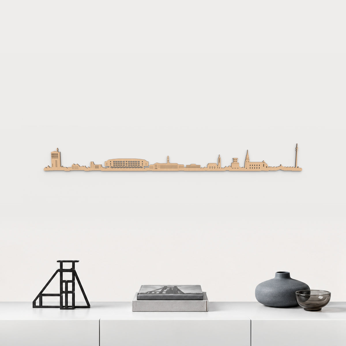Skyline von Gelsenkirchen mit braunem Finish, 100 cm, über dem weißen Möbelstück mit Stahl, Büchern und blaugrauer Keramik, in einer von der Stadt inspirierten Einrichtung.