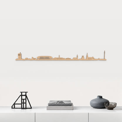 Skyline von Gelsenkirchen mit braunem Finish, 100 cm, über dem weißen Möbelstück mit Stahl, Büchern und blaugrauer Keramik, in einer von der Stadt inspirierten Einrichtung.