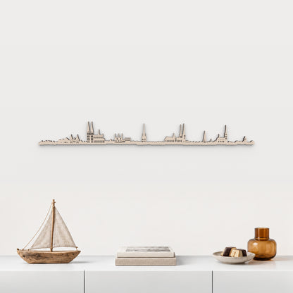 Skyline de Lübeck en madera natural sobre un mueble blanco, con decoración inspirada en la ciudad.