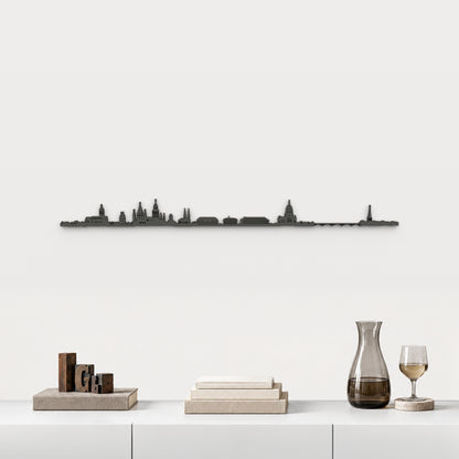 Skyline de Mainz en acabado negro, presentado sobre el mueble blanco con tipos de imprenta, libros, decantador y copa de vino, en una decoración inspirada en la ciudad.