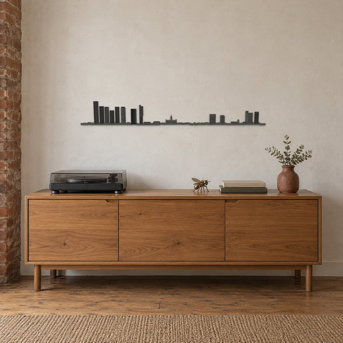 Skyline de Manchester negro de 100 cm sobre un aparador de madera, en un hogar con decoración inspirada en la ciudad.