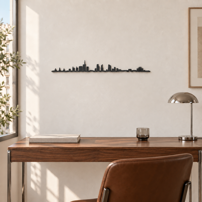 Skyline de Milán en madera negra sobre un escritorio con lámpara cromada y silla de cuero marrón.