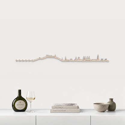 Skyline von Würzburg mit natürlichem Finish, 100 cm, über dem weißen Möbelstück mit fränkischem Wein, Büchern und Keramik, in einer von der Stadt inspirierten Einrichtung.